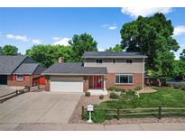 Charming two-story home featuring a well-manicured lawn, brick accents, mature trees, and a welcoming red front door at 7486 S Washington St, Centennial, CO 80122