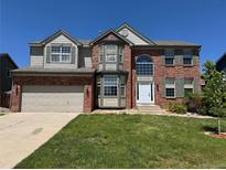 Charming two-story brick home with a well-manicured lawn, attached garage, and lovely architectural details at 1251 N Burlington Dr, Castle Rock, CO 80104