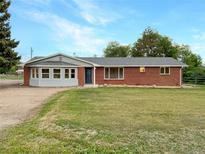 Charming single-story brick home with a well-maintained lawn and a welcoming front entrance at 12682 Anhawa Ave, Longmont, CO 80503
