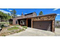 Charming exterior view of home featuring a two-car garage and lush landscaping at 18170 Forest View Rd, Monument, CO 80132