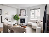 Bright living room features a modern fireplace, neutral decor, and large windows for ample natural light at 2820 W 26Th Ave # 101, Denver, CO 80211
