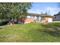 Charming single-story home with a well-manicured lawn, mature trees, and beautiful landscaping at 3061 S Mabry Ct, Denver, CO 80236