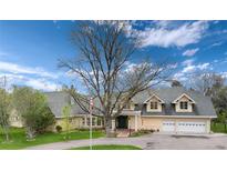 Stunning home with a circular driveway and a large tree in the front yard at 4800 S Franklin St, Cherry Hills Village, CO 80113