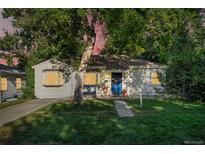Charming home with a well-maintained lawn, inviting walkway, mature shade trees, and a cozy front porch at 60 Vrain St, Denver, CO 80219