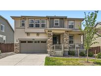 Beautiful two-story home showcasing a stone-accented porch and attached two-car garage at 14551 Hudson St, Thornton, CO 80602