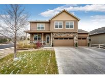 Charming two-story home features a stone facade, covered porch, and a three-car garage at 2177 Shadow Creek Dr, Castle Rock, CO 80104