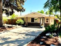 Charming single-story home featuring a stone facade, inviting front porch, and landscaped front yard at 404 S Jasmine St, Denver, CO 80224