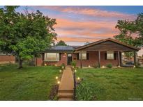 Charming red brick home featuring a well-manicured lawn and inviting walkway at sunset at 4293 Graham Ct, Boulder, CO 80305