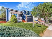 Charming home featuring a blue exterior, well-manicured lawn, and inviting front porch at 4257 S Andes Way, Aurora, CO 80013