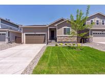 Charming single-Gathering home featuring a well-manicured lawn and a two-car garage at 18951 E 96Th Pl, Commerce City, CO 80022