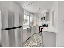 Modern kitchen with stainless steel appliances, bright countertops and a unique geometric tile floor at 215 E 11Th Ave # D8, Denver, CO 80203