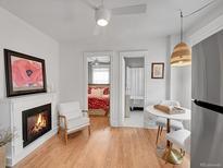 Bright living area with a fireplace, hardwood floors, and easy access to the bedroom and bathroom at 215 E 11Th Ave # D8, Denver, CO 80203