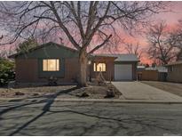 Charming brick home with covered porch, mature tree, and inviting curb appeal at sunset at 640 Marble St, Broomfield, CO 80020