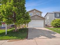 Charming two-story home with a well-manicured lawn and inviting curb appeal, perfect for a Gathering at 9697 Marmot Ridge Cir, Littleton, CO 80125