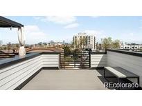 Relax on this rooftop deck with panoramic city views, offering a perfect spot for entertaining and enjoying the outdoors at 3520 W Connejos Pl # 5, Denver, CO 80204