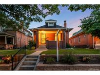 Charming brick home with a cozy front porch and well-maintained lawn at dusk at 534 S Pearl St, Denver, CO 80209
