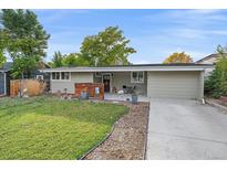 Charming one-story home boasts a well-manicured lawn and inviting front porch with seating at 7911 Raleigh Pl, Westminster, CO 80030