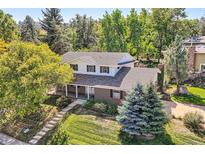 Charming two-story brick home with a lush green yard and mature trees, offering great curb appeal at 3150 Lane Ct, Boulder, CO 80305