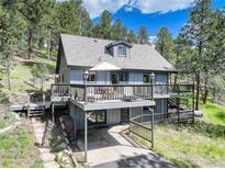 Charming two-story home features a spacious deck, covered parking, and beautiful mountain surroundings at 30221 Marge Ln, Evergreen, CO 80439