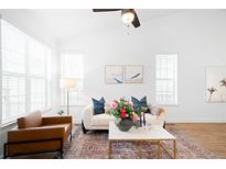 Bright living room with a stylish sofa, modern coffee table, and plenty of natural light from the large windows at 2028 Ulster St, Denver, CO 80238