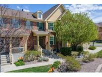 Charming brick townhome featuring manicured landscaping, inviting entrance, and sunny, bright curb appeal at 6365 Orion Ct # B, Arvada, CO 80403