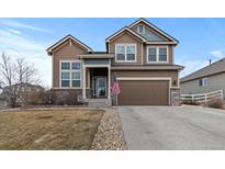 Inviting two-story home with a well-manicured lawn and a two-car garage, enhanced by a charming stone-lined driveway at 5404 Fawn Ridge Way, Castle Rock, CO 80104