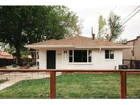 Charming home featuring a well-manicured lawn, a white brick exterior, and a cozy front porch with seating at 4422 W 27Th Ave, Denver, CO 80212