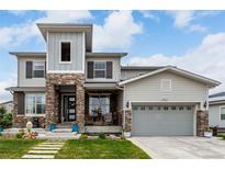 Charming two-story home with a stone facade, covered porch and manicured lawn at 5964 E 141St Ave, Thornton, CO 80602