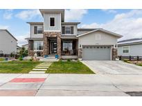 Inviting two-story home featuring a well-manicured front yard and stone accents at 5964 E 141St Ave, Thornton, CO 80602