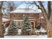 Charming brick home featuring a manicured front yard, mature trees, and a classic architectural design at 425 Monroe St, Denver, CO 80206