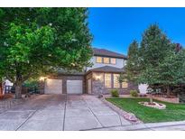 Charming two-story home with a stone facade, three-car garage, and well-maintained front yard with mature trees at 12350 Turquoise Terrace St, Castle Pines, CO 80108