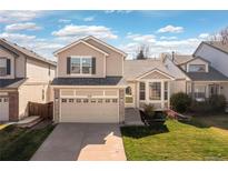 Charming two-story home with a well-manicured lawn and attached two-car garage at 1018 Mulberry Ln, Highlands Ranch, CO 80129
