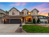 Beautiful two-story home featuring a three-car garage, brick accents, a well-manicured lawn and a cozy front porch at 7038 Russell Ct, Arvada, CO 80007