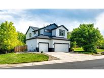 Two-story home boasts a two-car garage, manicured lawn, and a classic exterior paint scheme at 10890 Willow Reed West Cir, Parker, CO 80134
