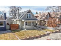 Charming two-story home with a well-manicured lawn, inviting front porch, and classic architectural details at 3825 Tejon St, Denver, CO 80211