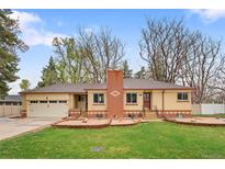 Charming ranch-style home featuring a brick chimney and attached two-car garage at 60 Yarrow St, Lakewood, CO 80226
