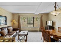 Comfortable living room featuring a large window with beautiful views and cozy seating arrangements at 640 Village Rd # 4220, Breckenridge, CO 80424