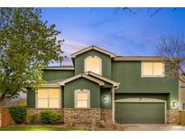 Charming two-story home featuring a stone facade, green exterior, and a two-car garage at 2119 W 101St Cir, Thornton, CO 80260