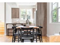 Open dining area with a wood table, black chairs, and modern decor near the kitchen at 2828 N Federal Blvd, Denver, CO 80211