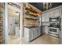 Charming kitchen features exposed brick, open shelving, modern appliances, and updated countertops at 1024 34Th St, Denver, CO 80205