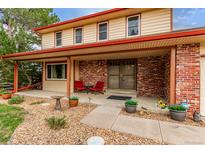 Charming two-story home featuring a brick facade, covered porch, and well-manicured landscaping at 18434 E Belleview Ln, Centennial, CO 80015