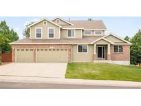 Charming two-story home with a brick and siding exterior and a spacious three-car garage at 1477 Serene Dr, Erie, CO 80516