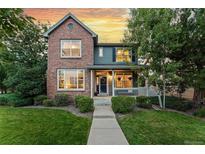 Charming two-story home with brick and siding exterior, landscaped yard, and inviting front porch at 12411 Irving Dr, Broomfield, CO 80020