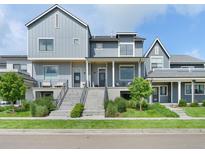 Stylish modern townhomes with well-manicured lawns, gray siding, and inviting front entrances at 385 East St, Louisville, CO 80027