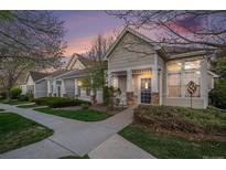 Charming home exterior featuring a well-maintained lawn and inviting front porch at dusk at 8300 Fairmount Dr # M103, Denver, CO 80247