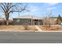 Charming single-story home featuring a unique stone facade, well-kept lawn, and lovely curb appeal at 13605 E 13Th Ave, Aurora, CO 80011