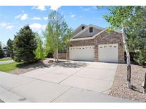 Charming brick home featuring a two-car garage and landscaped front yard at 744 Kryptonite Dr, Castle Rock, CO 80108