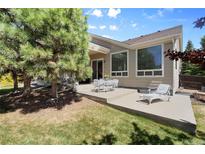 Outdoor patio with dining set, lounge chair, and well-maintained yard, perfect for relaxation and entertaining at 744 Kryptonite Dr, Castle Rock, CO 80108