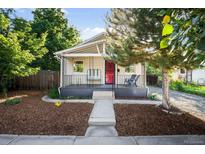 Charming single-story home with a cozy front porch and inviting curb appeal with lawn and walkway at 4955 Julian St, Denver, CO 80221