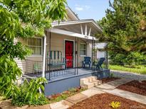 Charming front porch with seating, red door, and well-maintained landscaping provides curb appeal at 4955 Julian St, Denver, CO 80221